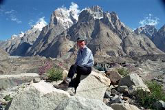 
Jerome Ryan Poses Above Lake On Baltoro Glacier With Great Trango Tower And Trango Castle Behind
